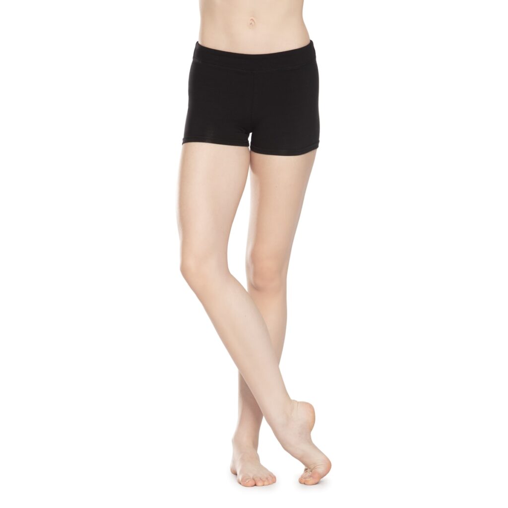 Woman wearing black fitted shorts, standing barefoot.