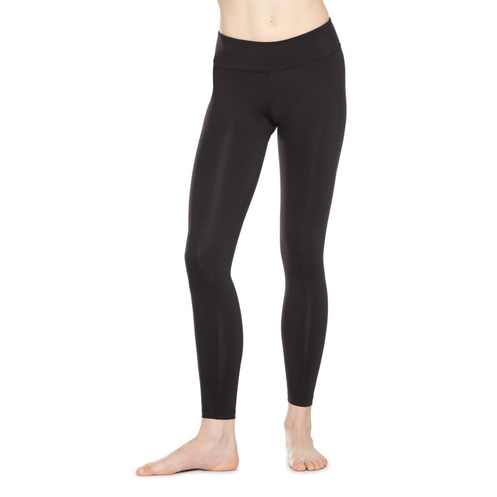 A person wearing black leggings standing barefoot.