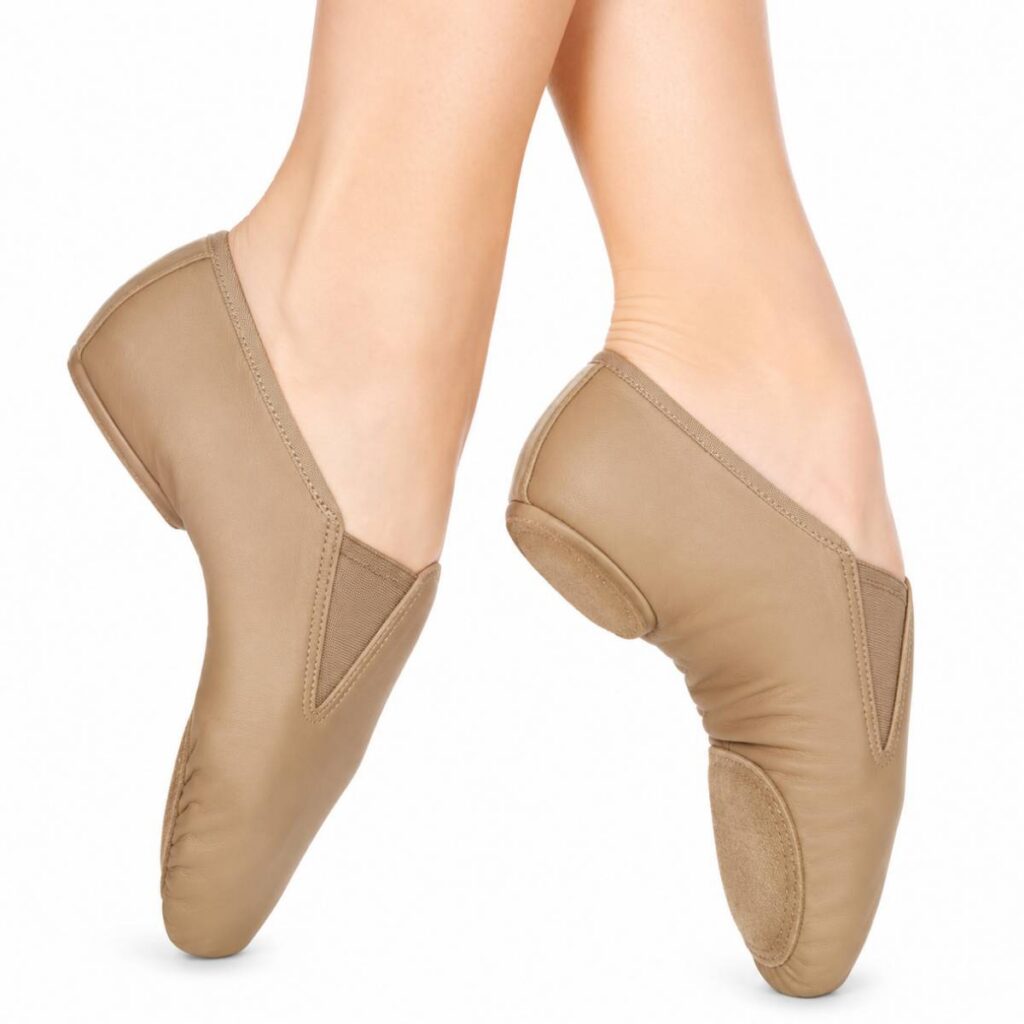 Pair of beige ballet slippers worn on feet.