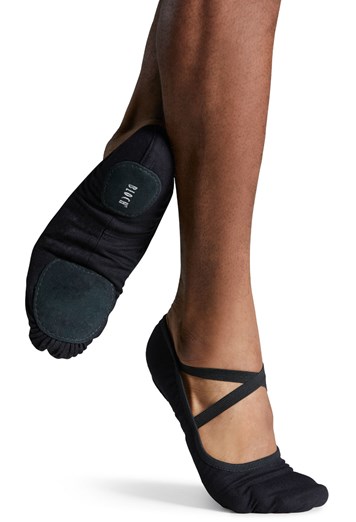 Close-up of feet wearing black ballet shoes with crisscross straps.