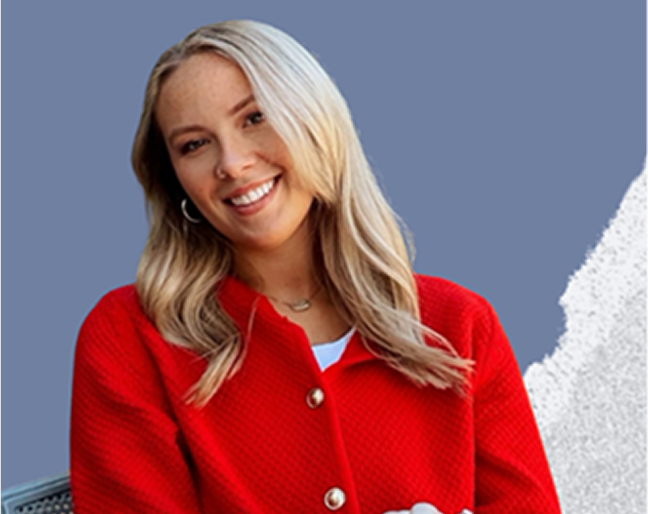 Smiling woman with blonde hair wearing a red sweater against a blue background.