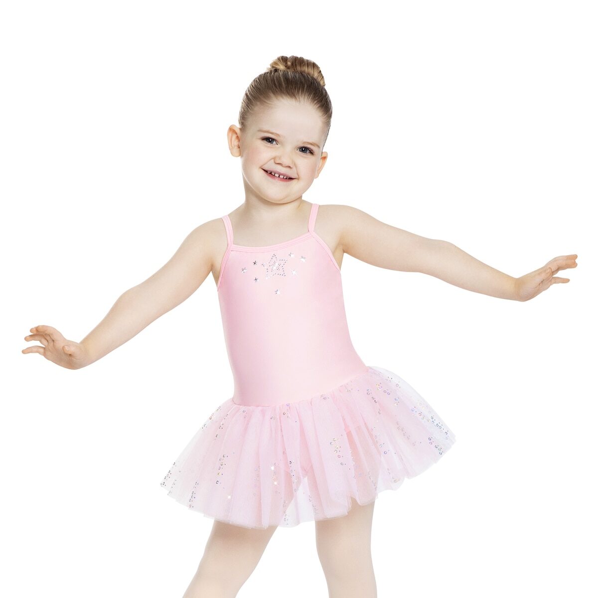 A young girl in a pink ballet costume posing with arms outstretched.