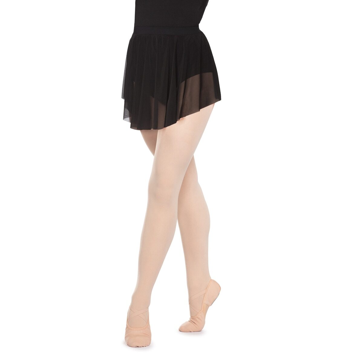 Person wearing a black skirt and beige tights standing barefoot.