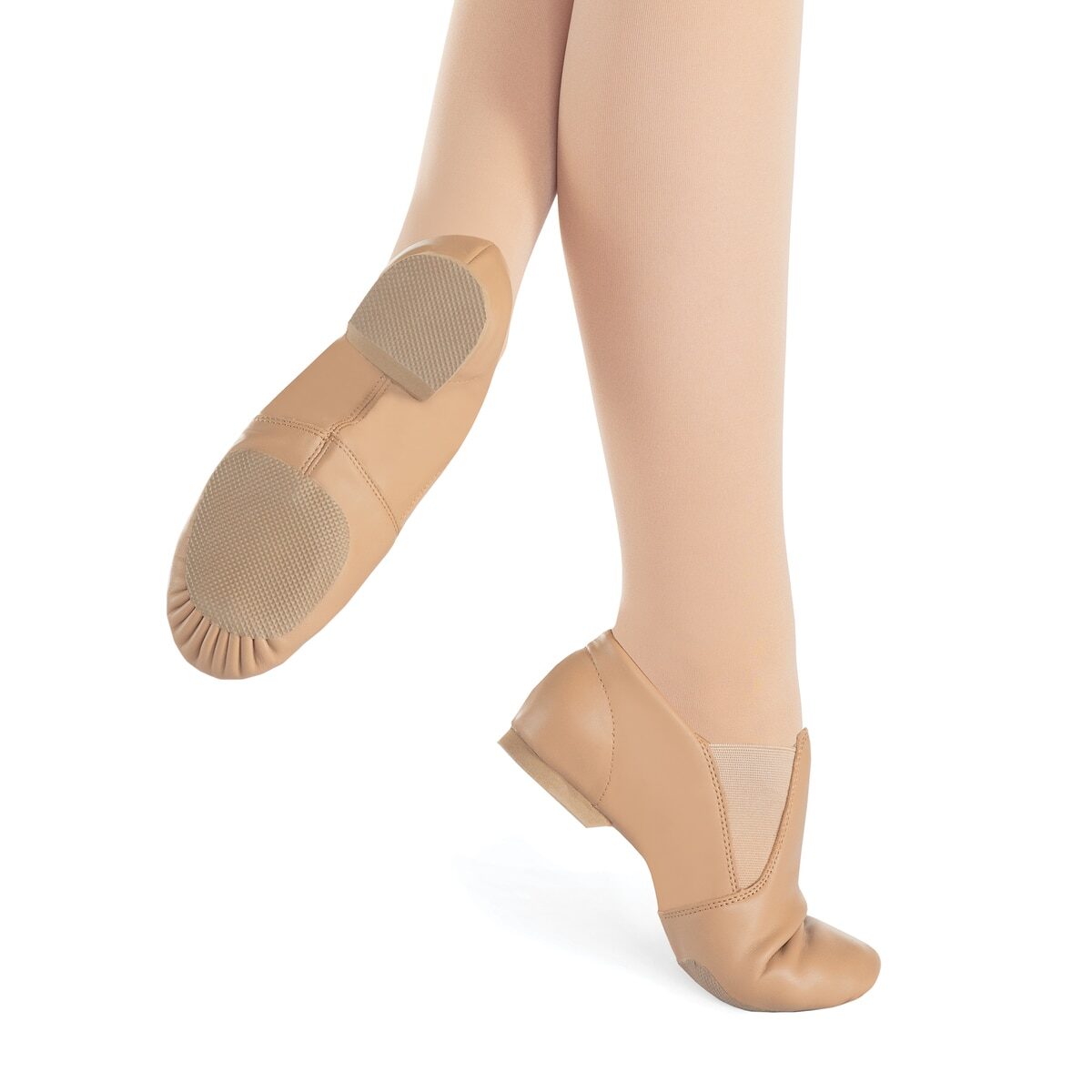 Person wearing tan ballet shoes with ankle straps.