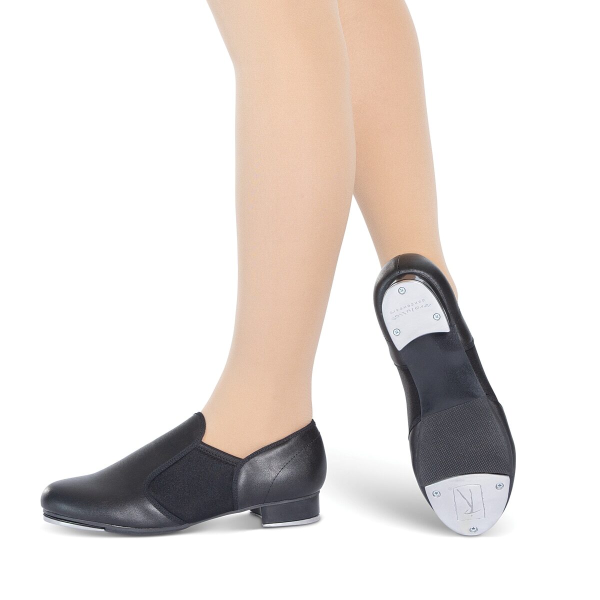Person wearing black jazz shoes on feet, shown from calf down.