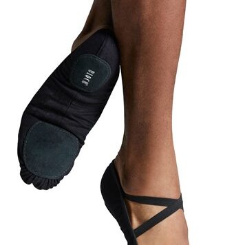 Close-up of feet wearing black ballet shoes with crisscross straps.